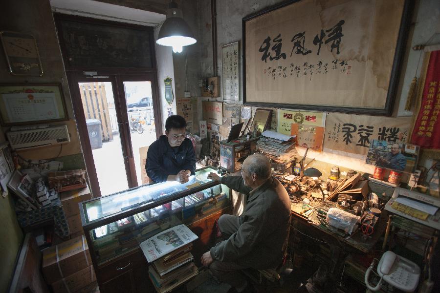 A young students consults to Zhang Guangyi for pen maintenance at Zhang's shop in Beijing, capital of China, April 26, 2013.  (Xinhua/Xu Zijian)