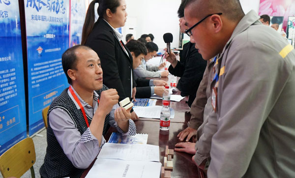A representative of recruitment enterprise talks with inmates who have employment intentions at Beijing Juvenile Delinquents Prison of China in Beijing, on May 2, 2013. Some 16 enterprises offered jobs to prisoners who are about to be released from jail, ultimately 30 people signed a letter of intent for employment. [Photo/Xinhua]