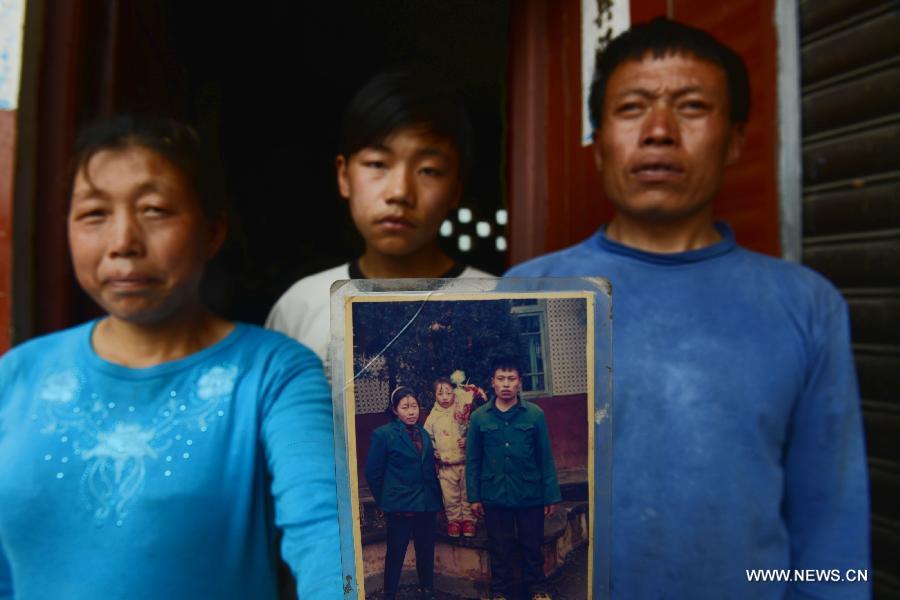 The Luo family pose for photo with an old picture in the quake-hit Longmen Village, southwest China's Sichuan Province, May 4, 2013. The old picture of the Luo couple and their daughter was taken in 1997 when their son hadn't been born. Old photos are not daily necessities for people who just suffered a 7-magnitude earthquake, but they are still cherished as they recorded people's past life and recalled memories. (Xinhua/Jin Liangkuai) 
