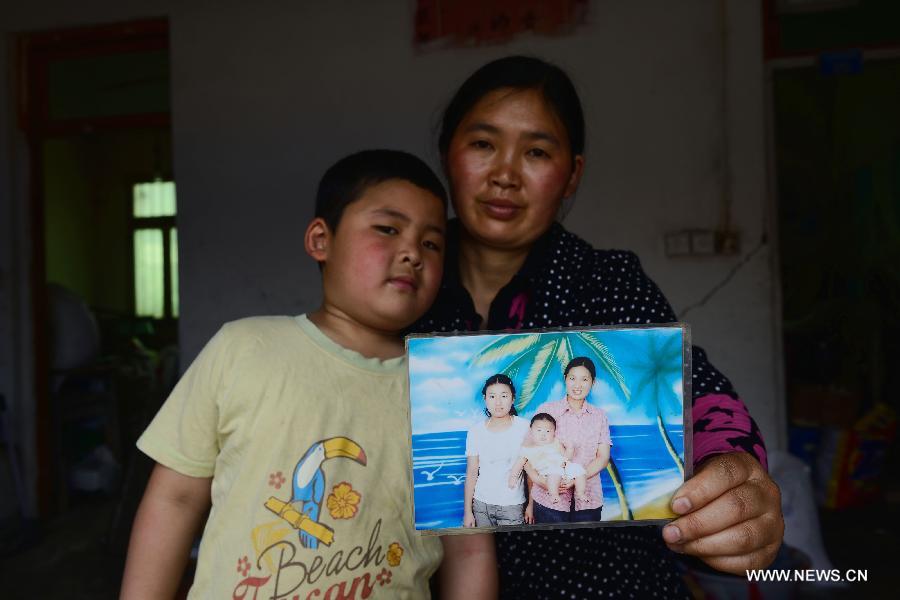 The 41-year-old Lu Shaorong and her 7-year-old son Huang Haixu pose for photo with an old picture in the quake-hit Longmen Village, southwest China's Sichuan Province, May 4, 2013. The old picture of Lv with her daughter and son was taken at a photo studio in 2006. Old photos are not daily necessities for people who just suffered a 7-magnitude earthquake, but they are still cherished as they recorded people's past life and recalled memories. (Xinhua/Jin Liangkuai)  
