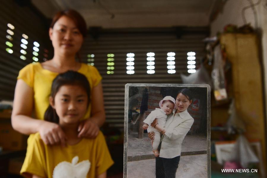 The 31-year-old Yang Hua and her 7-year-old daughter Pan Shirui pose for photo in the quake-hit Longmen Village, southwest China's Sichuan Province, May 4, 2013. The old picture beside them was taken at their yard in 2006. Old photos are not daily necessities for people who just suffered a 7-magnitude earthquake, but they are still cherished as they recorded people's past life and recalled memories. (Xinhua/Jin Liangkuai)  