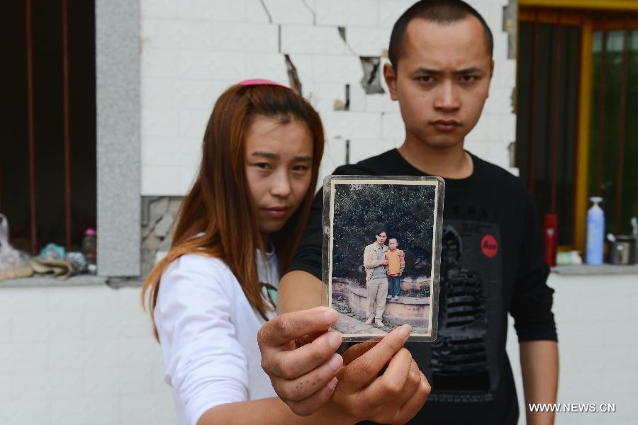 The 23-year-old Luo Yunchao (R) and his 20-year-old girlfriend Li Yanyan pose for photo with an old picture in the quake-hit Longmen Village, southwest China's Sichuan Province, May 4, 2013. The old picture of Luo and his brother was taken in 1997 when he was 7 years old. Old photos are not daily necessities for people who just suffered a 7-magnitude earthquake, but they are still cherished as they recorded people's past life and recalled memories. (Xinhua/Jin Liangkuai) 