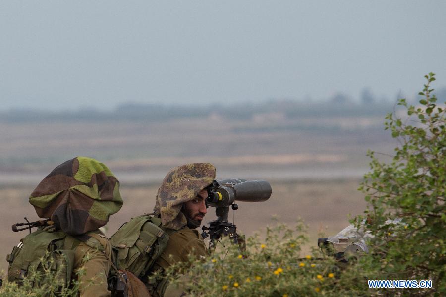 Israeli soldiers in an abandoned military outpost overlook the ceasefire line between Israel and Syria on the Israeli-occupied Golan Heights May 6, 2013. Israel Defense Forces (IDF) reported that 2 stray mortars shot from Syria landed in Golan Heights on Monday.(Xinhua/Jini)