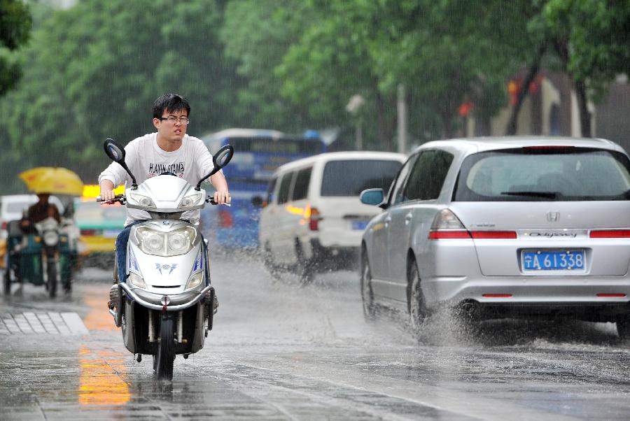 A man rides against rain in Yinchuan, capital of northwest China's Ningxia Hui Autonomous Region, May 7, 2013. The local meteorological observatory issued a yellow alert on thunderstorm on Tuseday as a thunderstorm hit Yinchuan the same day. (Xinhua/Peng Zhaozhi) 