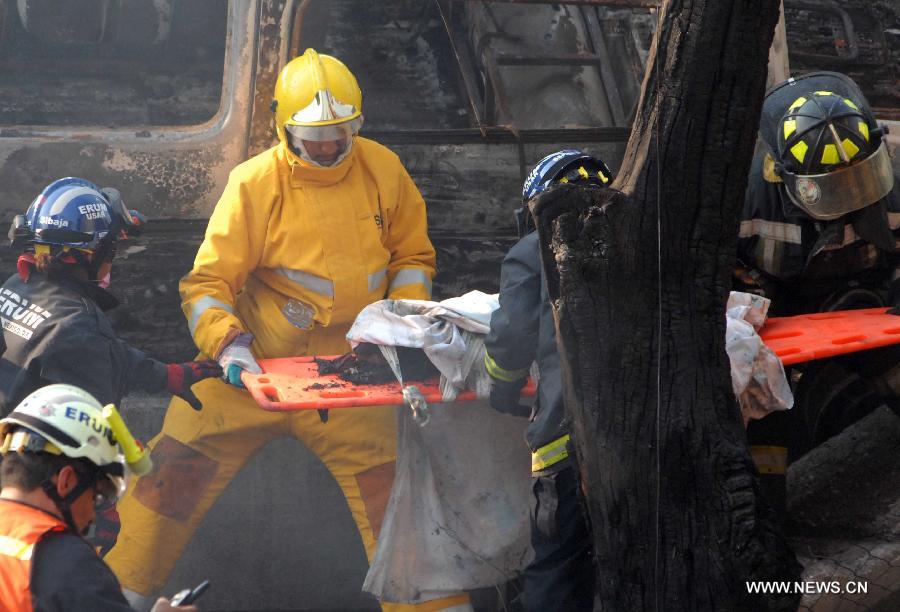 Firemen remove the body of a victim from the site of an explosion on the Mexico-Pachuca highway in Ecatepec, Mexico, on May 7, 2013. At least 20 people were killed and 34 injured when a gas tanker exploded early Tuesday in a Mexico City suburb, security officials said. (Xinhua/Susana Martinez) 