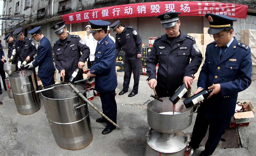 Police destroy counterfeit red wines in Shanghai, east China, May 7, 2013. Local police smashed over 3,000 bottles of counterfeit red wines worth of more than 40 million Yuan (approximately 6.5 million US dollars). (Xinhua/Fan Jun) 