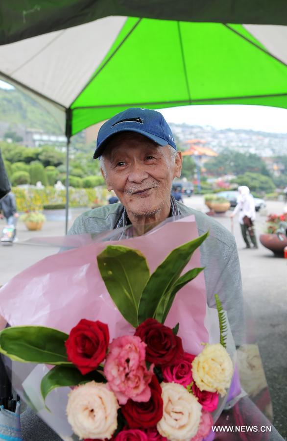 An 82-year-old fan holds a flower as he visits a cemetery in which Teresa Teng is tombed, in Xinbei City, southeast China's Taiwan, May 8, 2013. Fans from all over the world commemorated here on Wednesday the 18th anniversary of the death and 60th anniversary of the birth of Teresa Teng, the Taiwanese singer famous for her love songs. (Xinhua/Xie Xiudong)