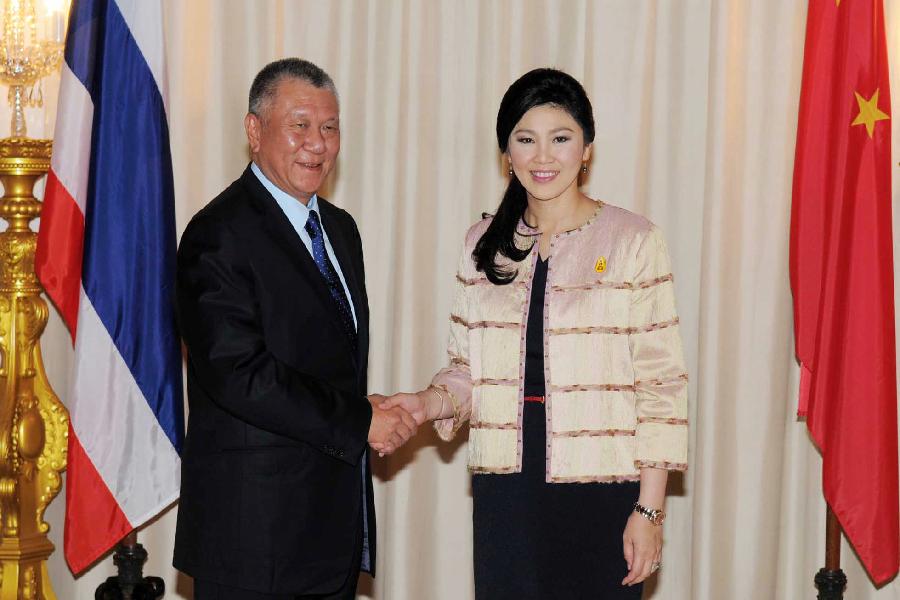 Edmund Ho (L), vice-chairman of the National Committee of the Chinese People's Political Consultative Conference, shakes hands with Thai Prime Minister Yingluck Shinawatra, at Government House in Bangkok, Thailand, May 9, 2013. (Xinhua/Rachen Sageamsak) 