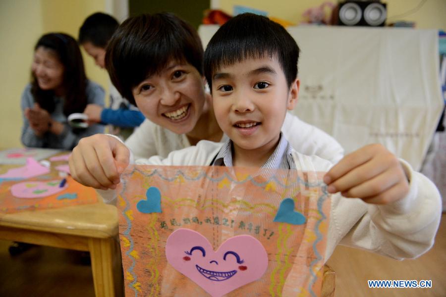A boy presents a handkerchief he made for his mother at a kindergarten in Hefei, capital of east China's Anhui Province, May 9, 2013. Children made cards, handkerchiefs and other gifts for their mother to celebrate the coming Mother's Day. (Xinhua/Zhang Duan) 