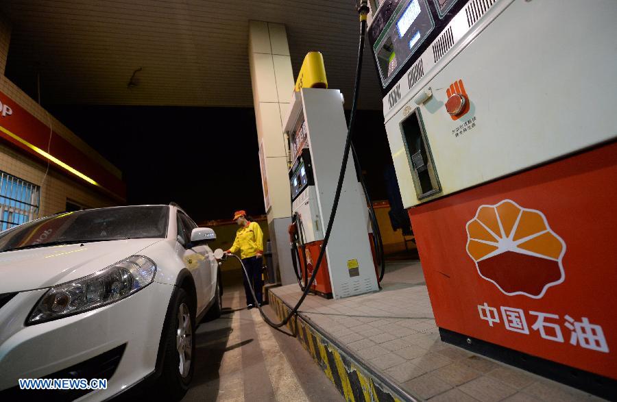 A gas station staff member refuels a car in Xi'an, capital of northwest China's Shaanxi Province, at the midnight on May 10, 2013. China slightly hiked gasoline and diesel prices starting May 10, the first increase since the fuel pricing scheme was reformed in March. The retail price of both gasoline and diesel was raised by 95 yuan (15.32 U.S. dollars) per tonne, the National Development and Reform Commission (NDRC), the country's top economic planner, said on May 9. The benchmark retail price of gasoline was increased by 0.07 yuan per liter and diesel by 0.08 yuan per liter. (Xinhua/Li Yibo)