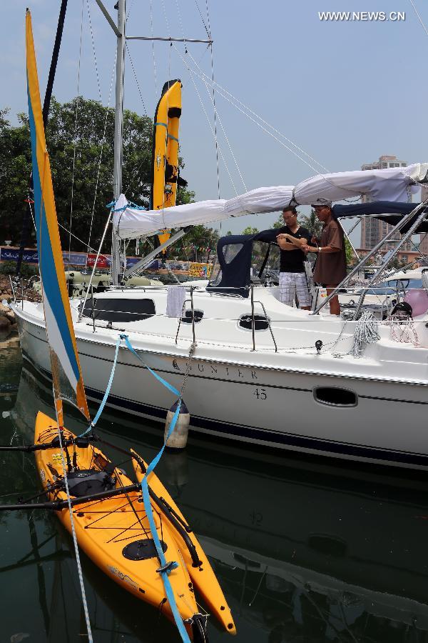 Photo taken on May 11, 2013 shows a yacht and a canoe at an exhibition held by the Gold Coast Yacht Country Club in Hong Kong, south China. The exhibition has attracted 70 exhibitors around the world with their luxurious yachts as well as a fancy lifestyle at sea. (Xinhua/Li Peng) 