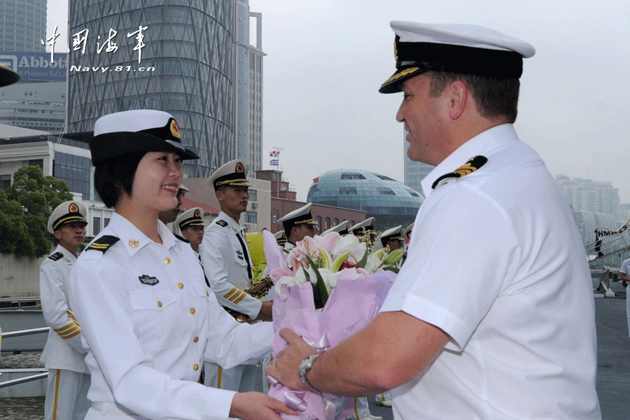 The picture shows that a Chinese female sailor presents a bouquet to Commander Andel (R), captain of the "Te Mana" frigate.