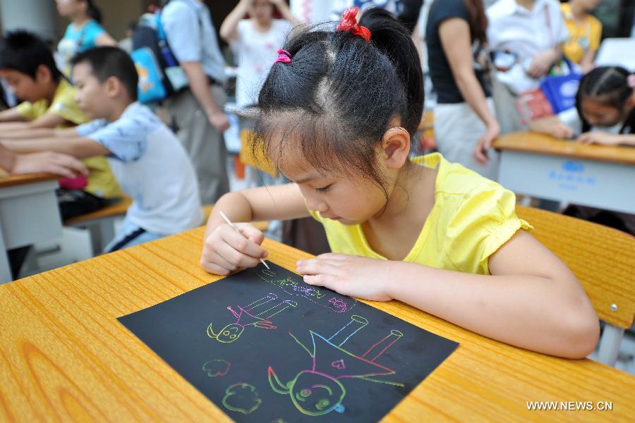 Ma Yuxin draws a picture of her mother during a celebration of the Mother's Day in Nanning, capital of south China's Guangxi Zhuang Autonomous Region, May 12, 2013. (Xinhua/Liu Jun) 