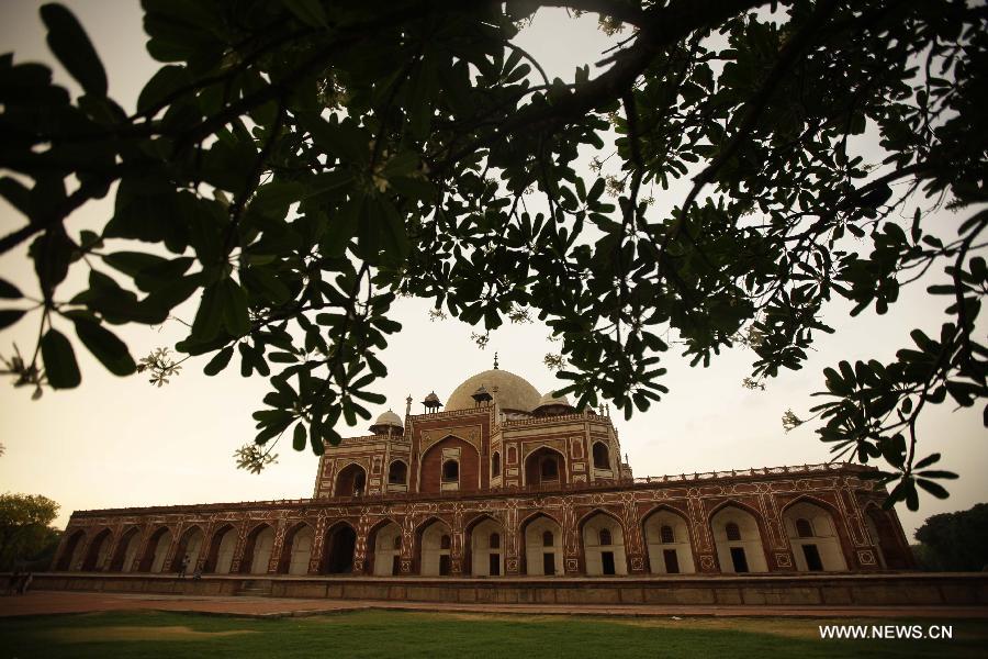 Photo taken on May 12, 2013 shows Humayun's Tomb at dusk in New Delhi, capital of India. Humayun's Tomb, located in east New Delhi, was built in 1569 to 1570 by Humayun's widow. As a precursor to the Taj Mahal, it stands on a platform of 12,000 square meters and reaches a height of 47 meters. The earliest example of the Persian influence in Indian architecture, the tomb itself is in the center of a large garden, surrounded by 12 hectares of gardens with pools joined by channels. The tomb brought Persian style to Delhi, but the two-tone combination of red sandstone and white marble is local, which shows the merging of different cultures. Humayun's Tomb was inscribed on the World Heritage List by the United Nations Educational, Scientific and Cultural Organization in 1993. (Xinhua/Zheng Huansong)