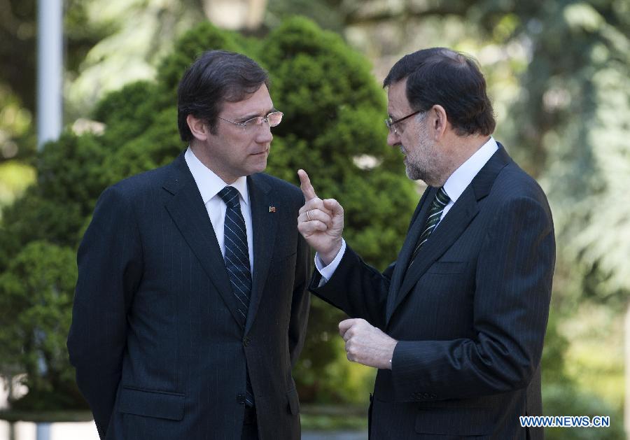 Spanish Prime Minister Mariano Rajoy (R) speaks with Portuguese Prime Minister Pedro Passos Coelho during their one-day summit meeting in Madrid, Spain, on May 13, 2013. (Xinhua/Xie Haining)