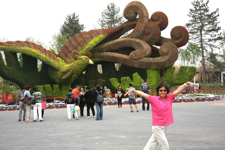 People taking pictures in front of a phoenix-shaped flower structure in the Ninth China (Beijing) International Garden Expo in western Beijing. The expo covers an area of 513 hectares, including 267-hecare public exhibition area and 246-hectare Garden Expo Lake. The event will officially kick off on May 18, 2013 and last for six months. (CRIENGLISH.com/Luo Dan)