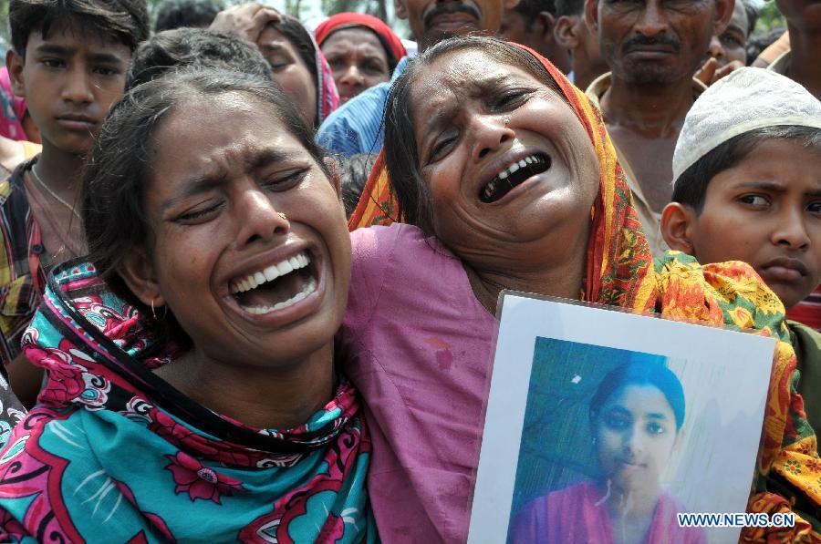 Women mourn over their missing relatives in front of the site of collapsed Rana Plaza building in Savar on the outskirts of Dhaka, Bangladesh, May 14, 2013. Twenty days into the collapse of the building when the confirmed death toll stands at 1,127, the rescuers wrapped up their recovery operations Tuesday morning. (Xinhua/Shariful Islam)