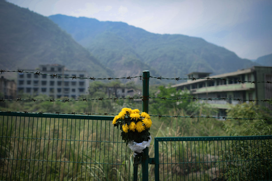 Flowers are tied on the fence to mourn for people killed in the Wenchuan Earthquake in Beichuan county, southwest China's Sichuan province, May 11, 2013. (Xinhua/Jiang Hongjing)