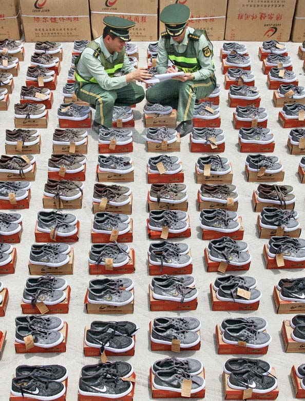 Police officials at Quanzhou Frontier Inspection Station counts seize fake sports shoes worth more than 12 million yuan (1.95 million U.S. dollars), May 9, 2013. (Xinhua/Deng Zhixin) 