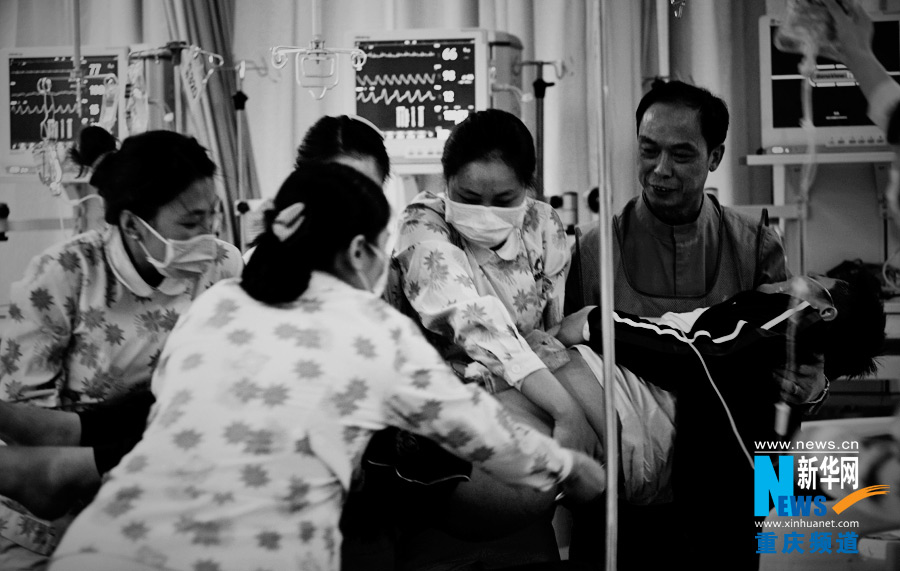 Doctors and nurses carry a patient to the bed.(Xinhua/Peng Bo)