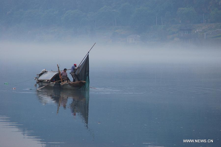 Fisherman steer a boat through fogs on the Xin'an River in Jiande, east China's Zhejiang Province, May 15, 2013. (Xinhua/Ning Wenwu) 
