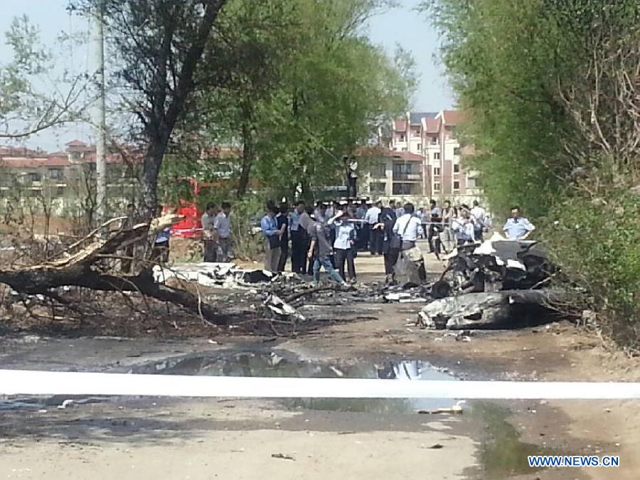 Photo taken on May 16, 2013 with a cellphone shows the site where a light plane failed to take off and crashed at Taoxian Airport in Shenyang, capital of northeast China's Liaoning Province. Three people on board were injured in the accident on Thursday. (Xinhua)
