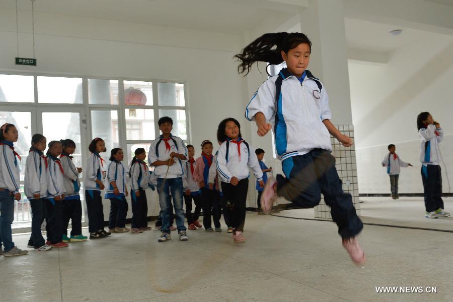 Students of the central primary school of Shangli Town play rope-skipping in a makeshift classroom in Shangli, Lushan County, southwest China's Sichuan Province, May 16, 2013. The schoolhouses of the Shangli Town Center School were destroyed in the 7.0-magnitude earthquake taken place in Lushan on April 20, leaving more than 1, 200 students to have classes in newly built prefab houses. (Xinhua/Liu Xiao)  