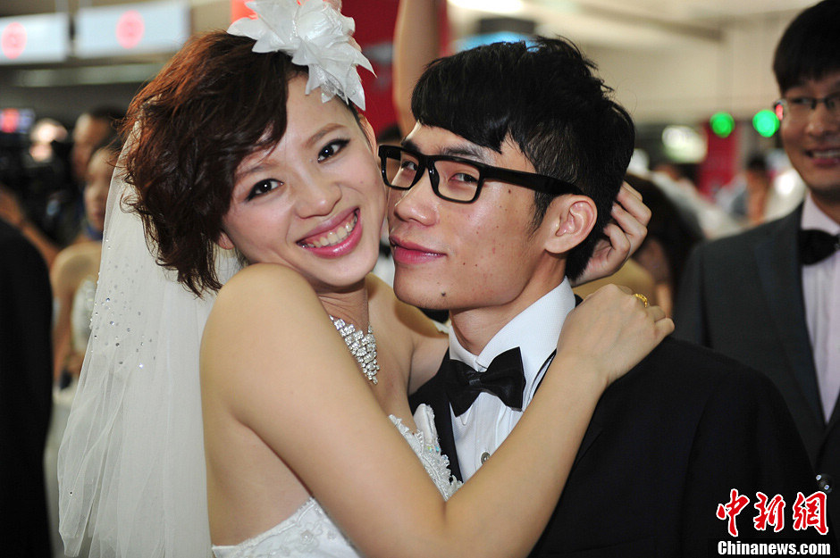 20 couples take subway to a collective wedding organized in Holiday Plaza in Shenzhen on May 19, 2013. Many citizens witness the happy moment. (CNS/Chen Wen)