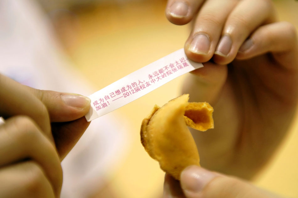 A small piece of paper with encouraging words lies in a fortune cookie made by the teacher to a student. The teachers in a middle school in Guangzhou held different activities to release the pressure on the students facing the college entrance examination in June. (Xinhua/Liang Xu)