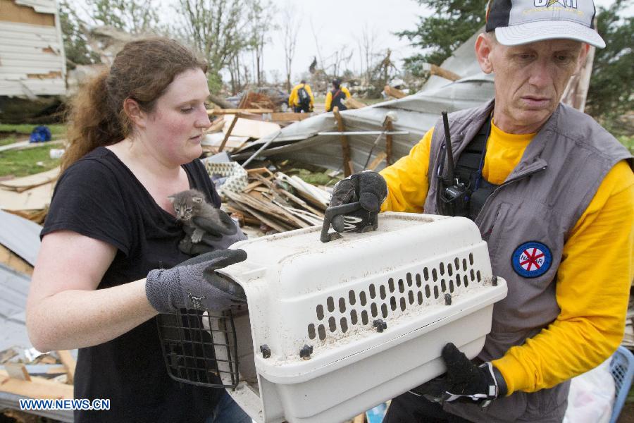 People rescue a cat on the wreckage in Shawnee, Oklahoma, the United States, May 20, 2013. Two men were confirmed dead after tornadoes hit the U.S. state of Oklahoma, officials said Monday. (Xinhua/Marcus DiPaola) 
