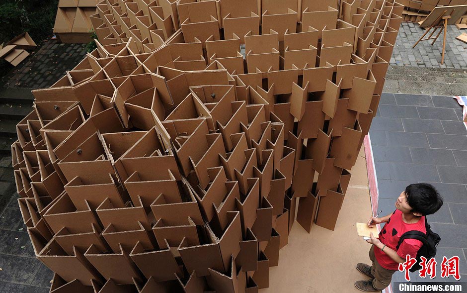 Students look a round a house made of paper boxes at Chongqing University in Southwest China's Chongqing Municipality, May 20, 2013. (CNS/Chen Chao)