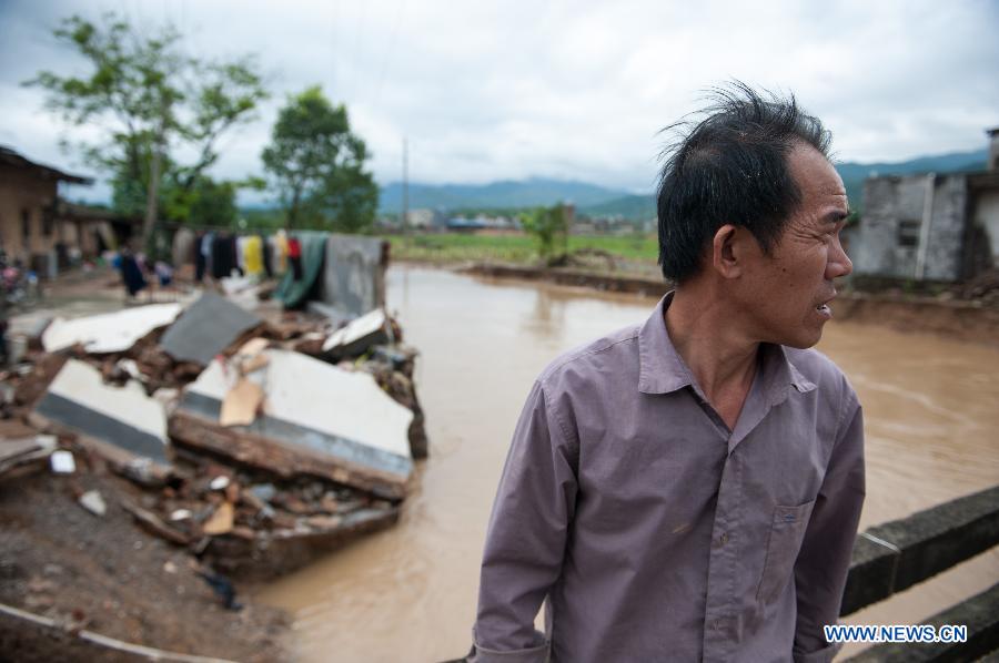 A villager stands beside his house destroyed by the rainstorm in Haoling Village of Jiaoling County, Meizhou City, south China's Guangdong Province, May 22, 2013. Meizhou City was hit by a rainstorm on May 19, which killed one people and destroyed 951 houses, leaving 180, 000 people affected in Jiaoling County. (Xinhua/Mao Siqian)
