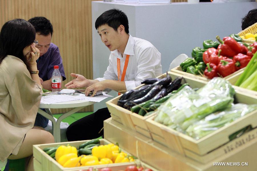 Dealers negotiate at the 7th International Organic Trade Fair and Conference (BioFach China) in Shanghai, east China, May 23, 2013. The three-day fair, which kicked off on Thursday, attracted 300 exhibitors from more than ten countries and regions. (Xinhua/Ding Ting) 