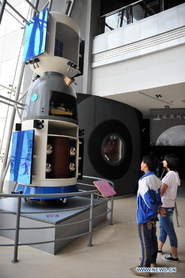 Visitors view a model of the capsule of Shenzhou-6 spacecraft during a scientific exhibition on lunar exploration in Guiyang, capital of southwest China's Guizhou Province, May 24, 2013. The exhibition, kicked off here Friday, showcased over 50 items. (Xinhua/Ou Dongqu)