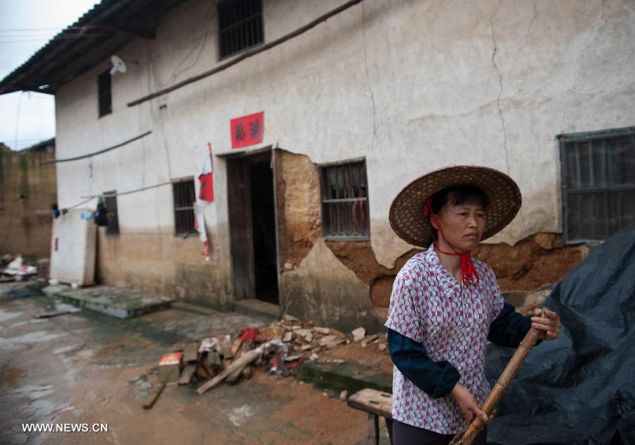 Zhong Weimei, 50, cleans in front of her house in Haoling Village of Jiaoling County, Meizhou City, South China's Guangdong Province, May 22, 2013. Zhong has two sons, both attending college in the provincial capital Guangzhou, which makes life more difficult for Zhong and her husband after the rainstorm hitting Guangdong Province on May 18. With the youth attending school or working outside their hometowns, the left-behind family members are becoming even more vulnerable after natural disasters. (Xinhua/Mao Siqian) 