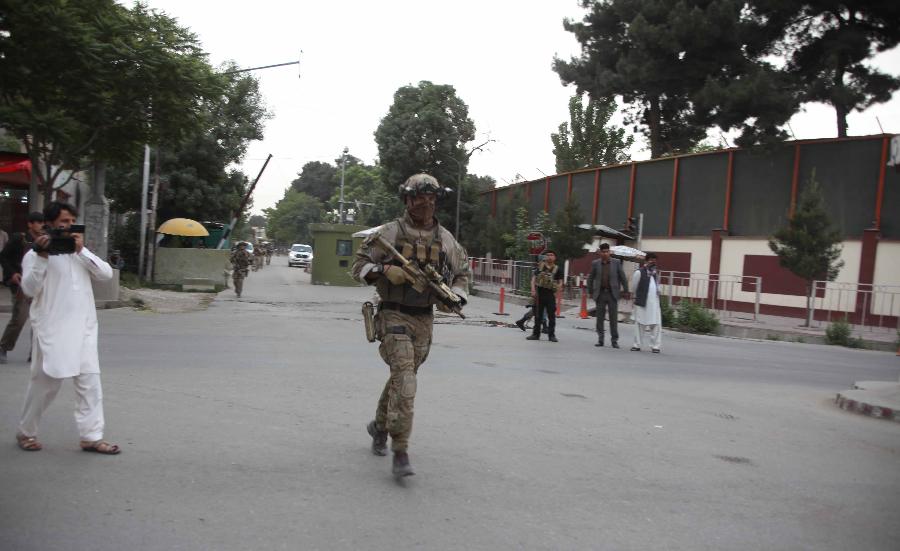 An Afghan soldier runs at the site of an attack in Kabul, Afghanistan on May 24, 2013. At least two suicide bombers and a policeman were killed and several others wounded on Friday evening when Taliban launched a coordinated attack in central Kabul, a police source said. (Xinhua/Ahmad Massoud) 