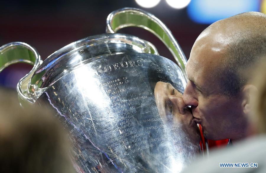 Arjen Robben of Bayern Munich kisses the trophy after the awarding ceremony for the UEFA Champions League final football match between Borussia Dortmund and Bayern Munich at Wembley Stadium in London, Britain on May 25, 2013. Bayern Munich claimed the title with 2-1.(Xinhua/Wang Lili)