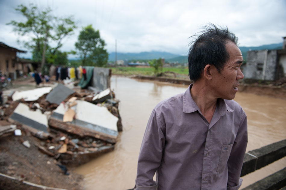 A villager stands in front of his home which was destroyed by flood in Jiaoling county, Guangdong province on May 22, 2013. A heavy rain hit Meizhou, Guangdong province, on May 19, killing one person and affecting 180,000. (Xinhua Photo/ Mao Siqian)