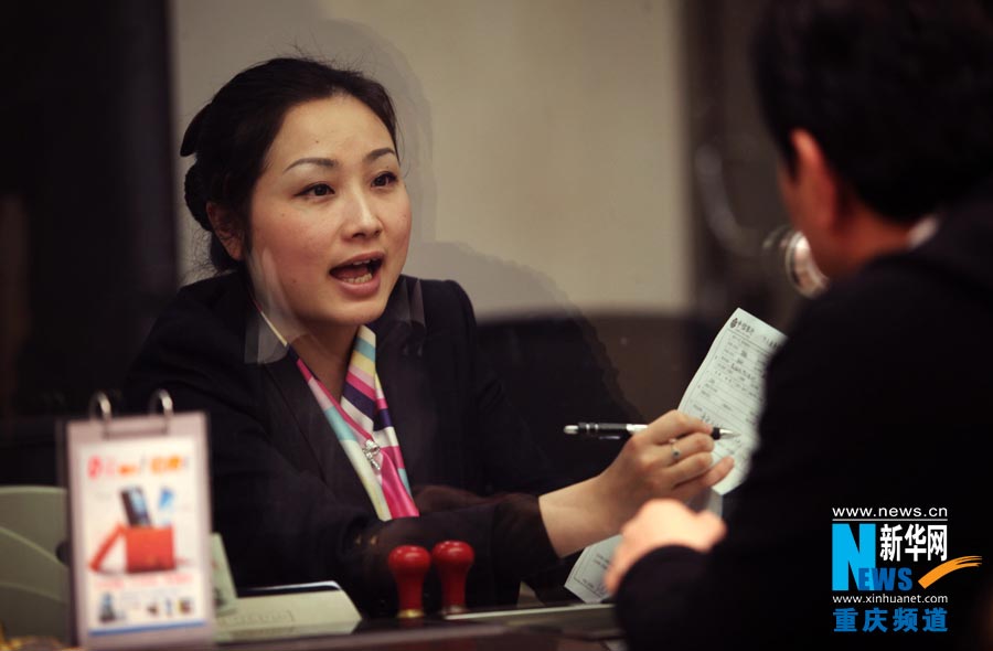 A bank teller serves a client. (Photo/Xinhua)