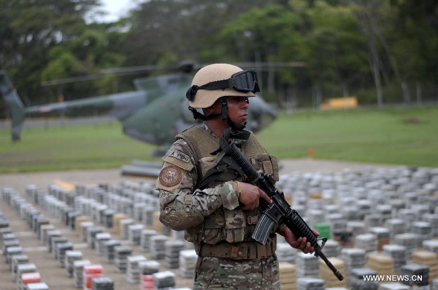 A member of the Aeronaval National Service guards cocaine packs siezed in the "Santisima Trinidad" operation, in the Guna Yala shire, during a presentation to media, in Panama City, capital of Panama, on May 27, 2013. According to official sources, the 2,717 kilograms of cocaine and two kilograms of marijuana are the biggest drug seizure by now in 2013, accomplished with United States support. The Aeronaval National Service has seized over 10,000 kilograms of illegal substances so far this year. (Xinhua/Mauricio Valenzuela) 