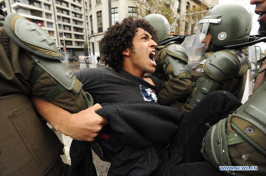 Riot policemen arrest a man during a protest called by the Chilean Coordinating Assembly of High School Students (ACES), the Chilean National Coordination of Students of High School (Cones), the Council of Student Federations of Chile (CONFECH) and the Movement of Students of Private Higher Education (MESUP), in Santiago, capital of Chile, on May 28, 2013. The students demanded a dignified and free education without lucre, according to local media. (Xinhua/Jorge Villegas) 