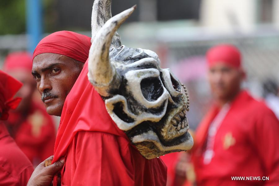 Dancers called "Diablos" of Yare, visit town's shrines on the frame work of Corpus Christi celebrations, at San Francisco de Yare population, in Miranda State, Venezuela, on May 29, 2013. The dancing diablos of Yare pay promises dancing with devil suits, making sound with percussions, along Yare streets. On December 6, 2012, these dancers were declared Humanity's Cultural Intangible Heritage by United Nations for Education, Science and Culture Organization (UNESCO). (Xinhua/Juan Carlos Hernandez)
