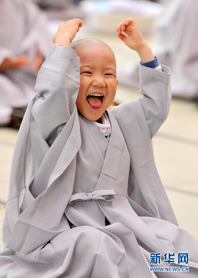 A young little monk laughs after ordained at Jogyesa Temple in Seoul, South Korea, May. 3, 2012. The Jogyesa temple held activities on that day in preparation for Buddha's Birthday on May 17. (Photo/Xinhua)   