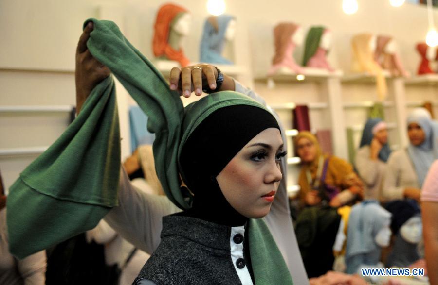 A model is helped to wear hijab during Indonesia Islamic Fashion Fair in Jakarta, Indonesia, May 31, 2013. The event was held from May 30 to June 2. (Xinhua/Agung Kuncahya B.) 