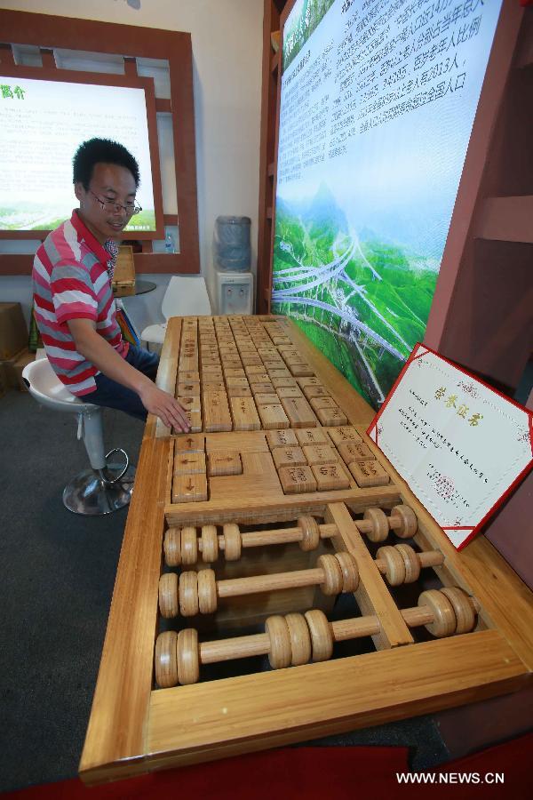 A visitor experiences a huge bamboo-made keyboard at China Beijing International Fair for Trade in Services (Beijing Fair) in Beijing, capital of China, May 31, 2013. (Xinhua/Chen Jingsu) 