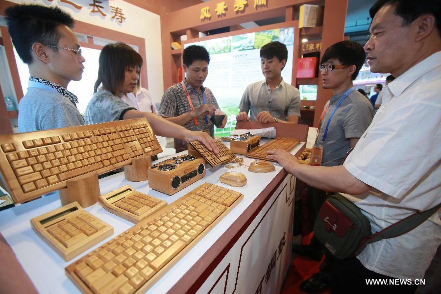 Visitors watch bamboo-made electronic products at China Beijing International Fair for Trade in Services (Beijing Fair) in Beijing, capital of China, May 31, 2013. (Xinhua/Chen Jingsu) 