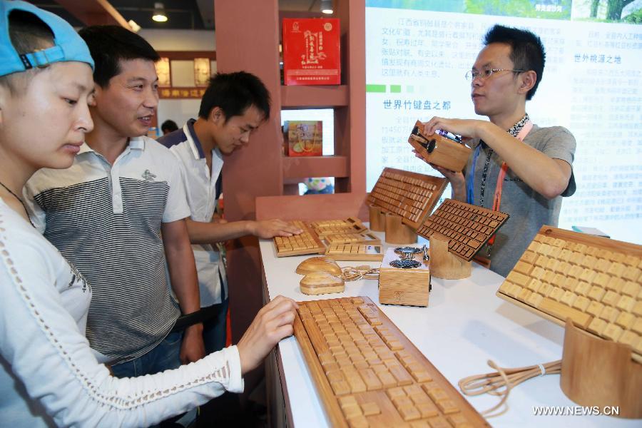 A staff member introduces bamboo-made electronic products at China Beijing International Fair for Trade in Services (Beijing Fair) in Beijing, capital of China, May 31, 2013. (Xinhua/Chen Jingsu)