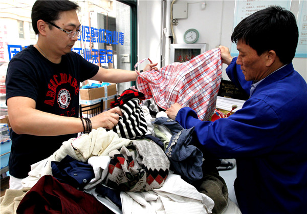 A resident donates more than 100 items of clothes to the community charity store in Shanghai, June 2, 2013. The store is the city's first community charity store, selling daily necessities as well as used clothes donated by residents capped at 50 yuan. The store receives more than 50,000 donated clothes a year from around 120 local residents a month. All the revenue is donated to charity organizations to help more people in need. 