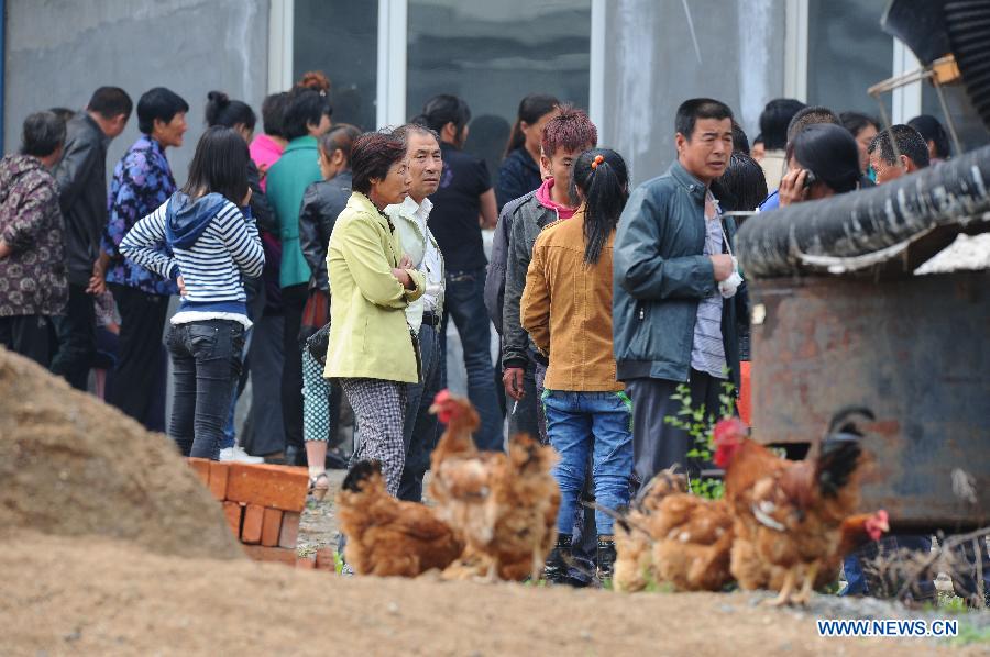 Family members of missing workers wait for information after a fire occurred in a slaughterhouse owned by the Jilin Baoyuanfeng Poultry Company in Mishazi Township of Dehui City, northeast China's Jilin Province, June 3, 2013. Death toll from the poultry processing plant fire on Monday morning has risen to 119. Over 300 workers were in the plant when the accident happened. (Xinhua/Xu Chang)