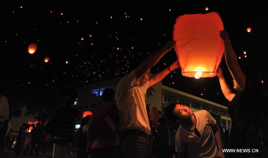 A high school graduate flies a sky lantern with his parents, wishing for good luck in the coming national college entrance exams in Maotanchang Township of Lu'an City, east China's Anhui Province, June 4, 2013. High school graduates will take part in the national college entrance exams set for June 7-8. (Xinhua/Guo Chen)